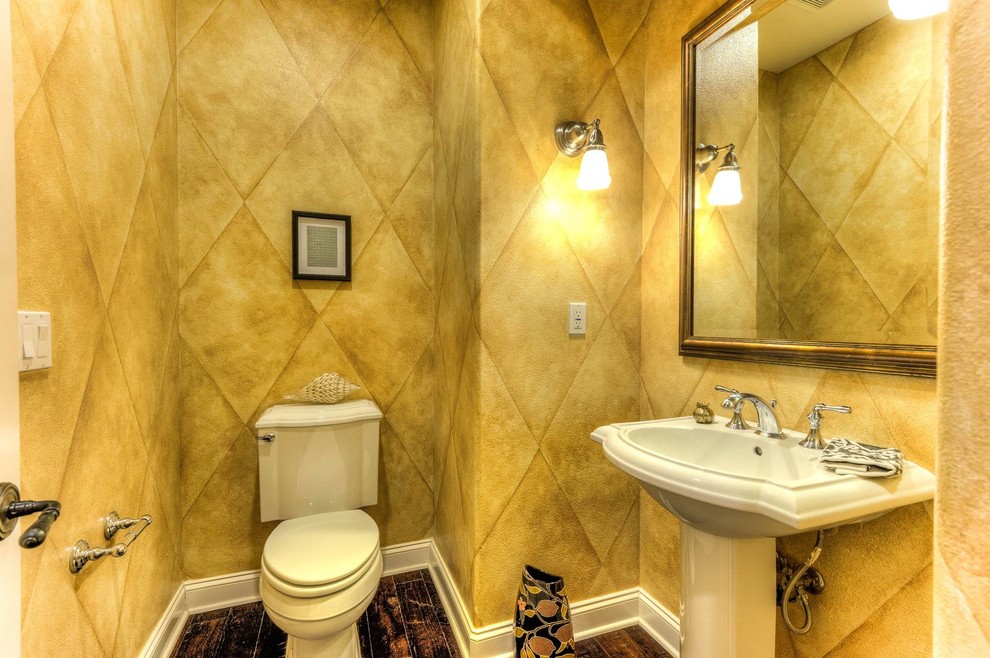 Mittelgroße Mediterrane Gästetoilette mit gelber Wandfarbe, dunklem Holzboden, Sockelwaschbecken und braunem Boden in Orange County