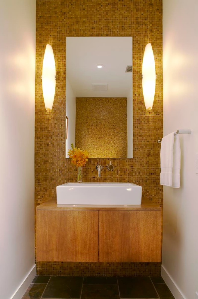 This is an example of a modern cloakroom in Los Angeles with a vessel sink, flat-panel cabinets, medium wood cabinets, wooden worktops, yellow tiles, mosaic tiles, porcelain flooring, yellow walls and brown worktops.