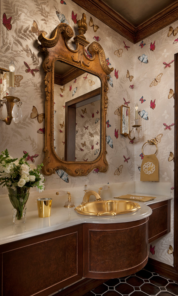 Inredning av ett klassiskt stort toalett, med möbel-liknande, bruna skåp, flerfärgade väggar, ett nedsänkt handfat och brunt golv