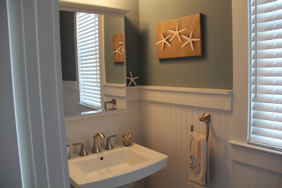 Bild på ett litet maritimt toalett, med grå väggar och ett piedestal handfat