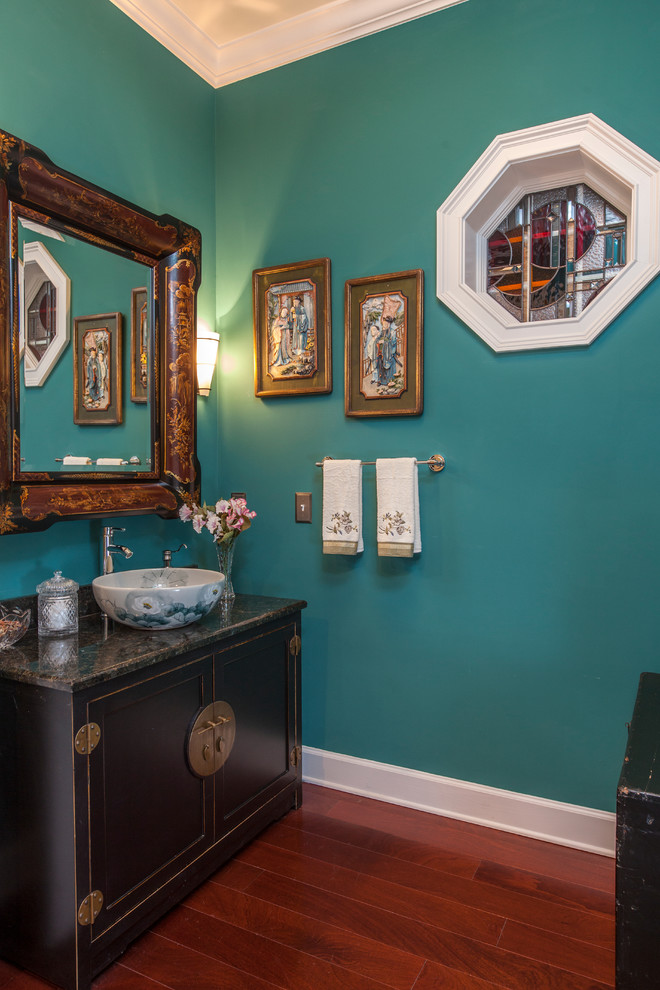 Ispirazione per un bagno di servizio etnico di medie dimensioni con lavabo a bacinella, consolle stile comò, ante nere, top in granito, pareti blu e pavimento in legno massello medio