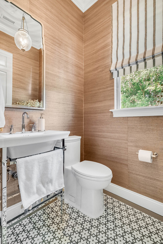 Foto di un bagno di servizio classico di medie dimensioni con WC monopezzo, pareti marroni, pavimento con piastrelle a mosaico, lavabo a consolle, top in superficie solida e pavimento multicolore