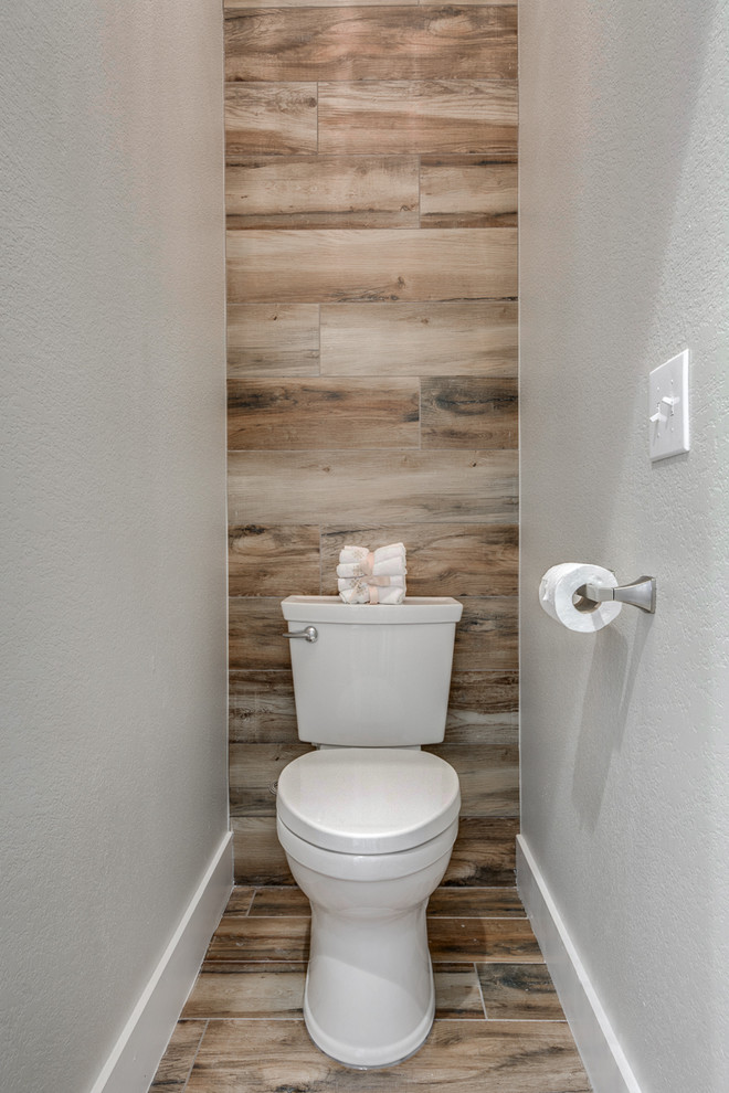 Cette photo montre un grand WC et toilettes moderne avec un lavabo posé, WC séparés, un mur blanc et un sol en bois brun.
