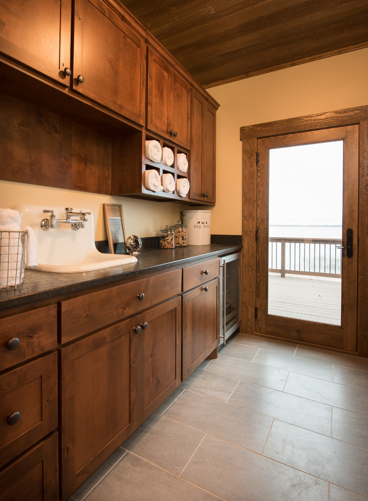 This is an example of a rustic cloakroom in Minneapolis with recessed-panel cabinets, dark wood cabinets and beige walls.
