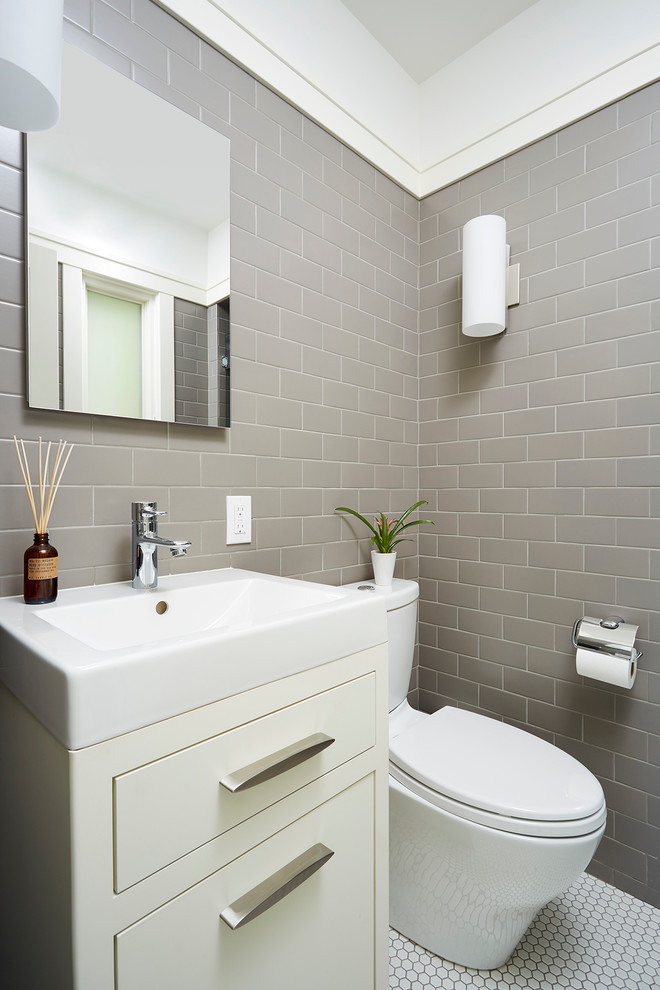ミネアポリスにあるトランジショナルスタイルのおしゃれなトイレ・洗面所 (フラットパネル扉のキャビネット、分離型トイレ、グレーのタイル、サブウェイタイル、ベージュのキャビネット、白い床) の写真