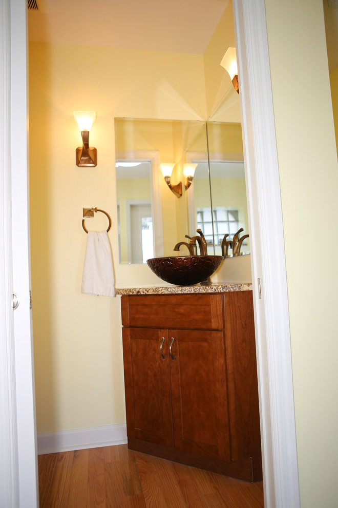 Gästetoilette mit Aufsatzwaschbecken, Schrankfronten im Shaker-Stil, hellbraunen Holzschränken, Granit-Waschbecken/Waschtisch und Wandtoilette mit Spülkasten in St. Louis