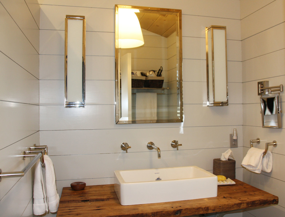 Diseño de aseo tradicional renovado de tamaño medio con armarios abiertos, paredes blancas, lavabo sobreencimera y encimera de madera