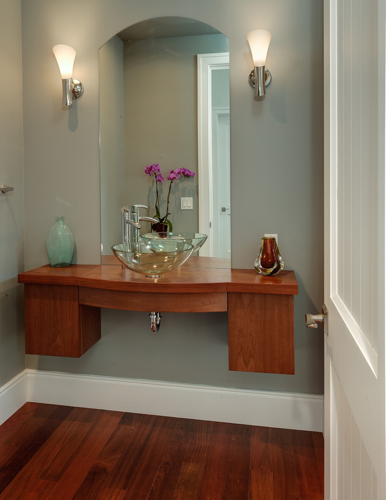 Powder room - small contemporary medium tone wood floor powder room idea in Other with a vessel sink, flat-panel cabinets, medium tone wood cabinets, wood countertops, a one-piece toilet and gray walls