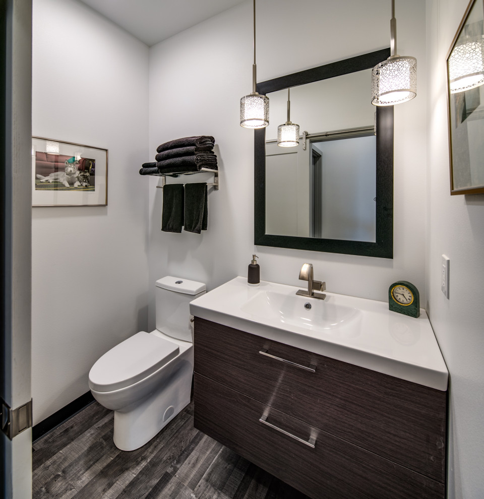 Design ideas for a medium sized contemporary cloakroom in Seattle with flat-panel cabinets, black cabinets, a two-piece toilet, grey walls, vinyl flooring, an integrated sink, quartz worktops, grey floors and white worktops.