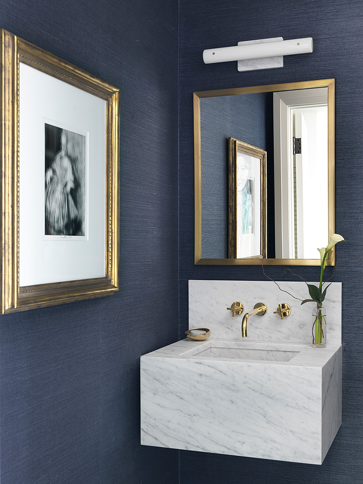 Inredning av ett modernt toalett, med blå väggar och ett väggmonterat handfat