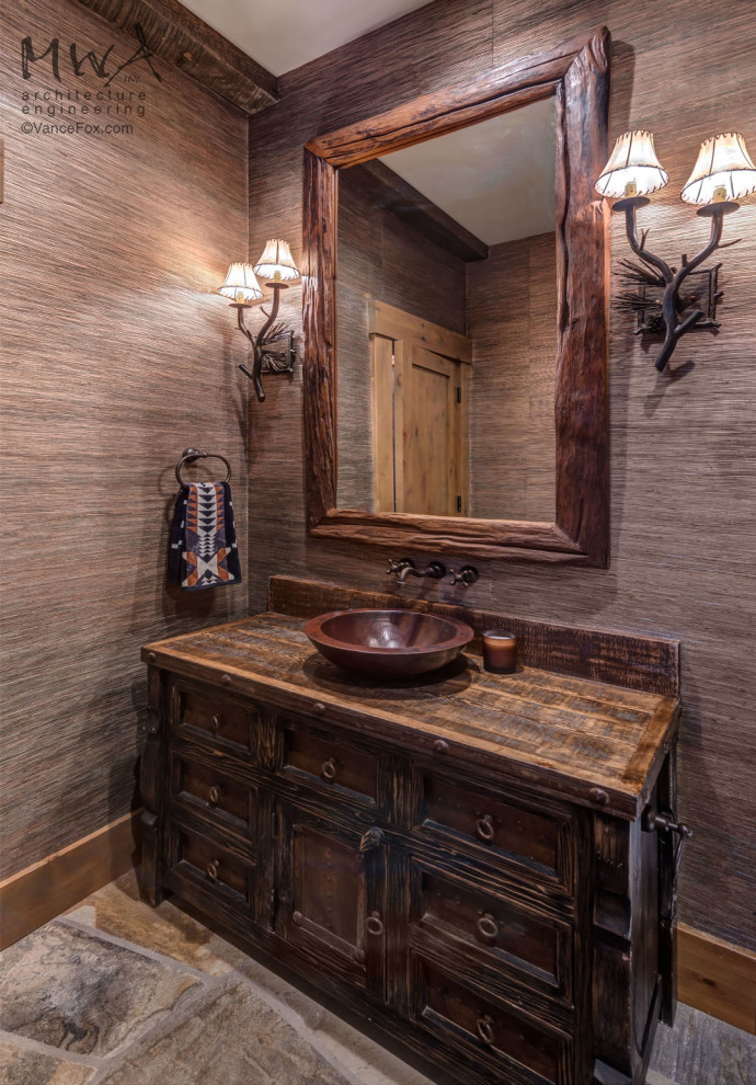 This is an example of a medium sized classic cloakroom in Other with recessed-panel cabinets, dark wood cabinets, grey walls, slate flooring, a vessel sink, wooden worktops, multi-coloured floors, brown worktops, a freestanding vanity unit and wallpapered walls.