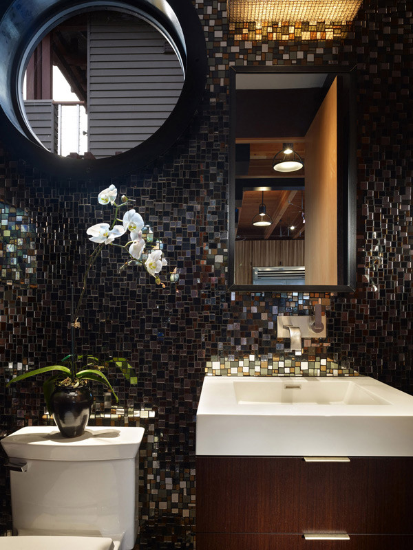 Small minimalist black tile and glass tile concrete floor and beige floor powder room photo in Seattle with an integrated sink, flat-panel cabinets, dark wood cabinets, a two-piece toilet, black walls, solid surface countertops and white countertops
