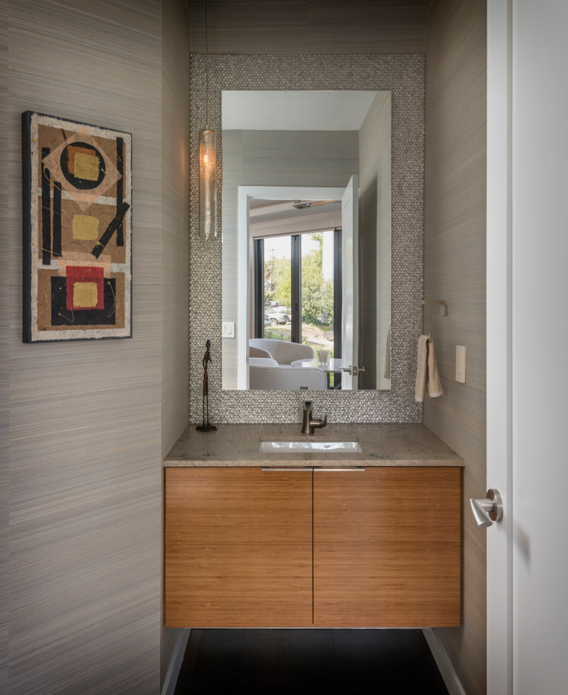 На фото: туалет в современном стиле с плоскими фасадами, коричневыми стенами, врезной раковиной, коричневой столешницей, подвесной тумбой, обоями на стенах и светлыми деревянными фасадами с