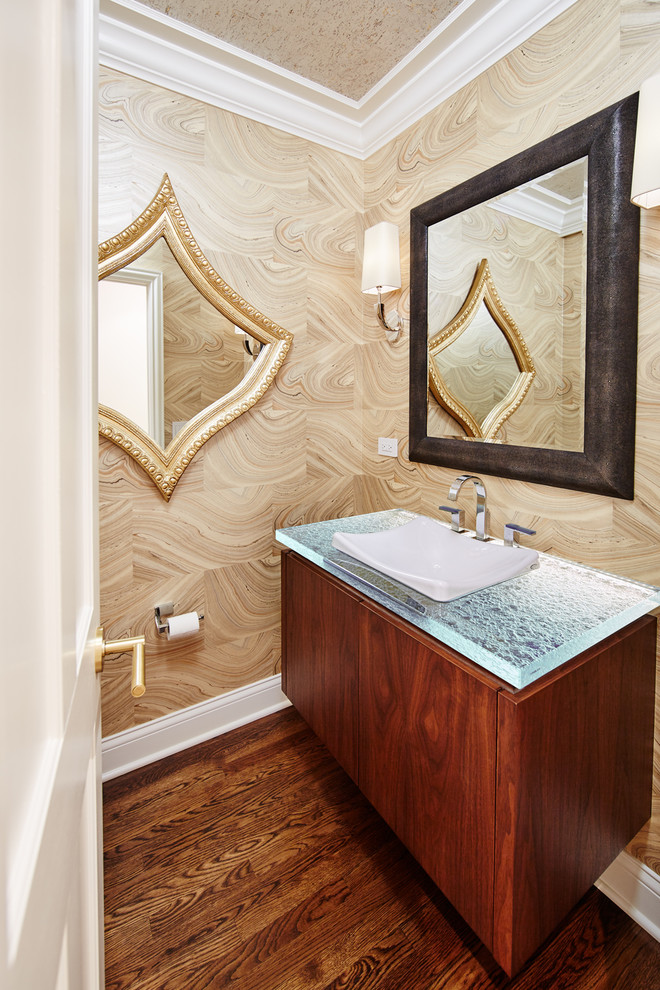 Idée de décoration pour un WC et toilettes design en bois brun avec un placard à porte plane, un plan de toilette en verre, un mur beige, un sol en bois brun, un sol marron et un plan de toilette bleu.