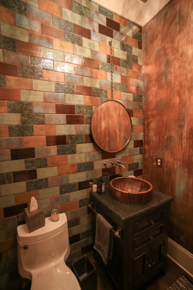 Rustik inredning av ett litet toalett, med möbel-liknande, skåp i mörkt trä, en toalettstol med hel cisternkåpa, flerfärgad kakel, keramikplattor, flerfärgade väggar, mörkt trägolv, ett fristående handfat och granitbänkskiva