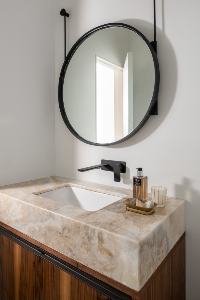Idee per un piccolo bagno di servizio design con ante lisce, ante in legno scuro, pareti bianche, lavabo sottopiano e top beige
