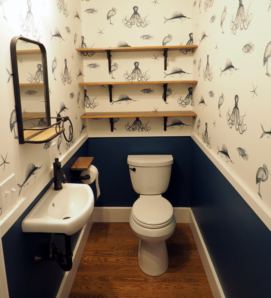 Idée de décoration pour un petit WC et toilettes tradition avec WC séparés, un mur bleu, un sol en bois brun, un lavabo suspendu, meuble-lavabo suspendu et du papier peint.