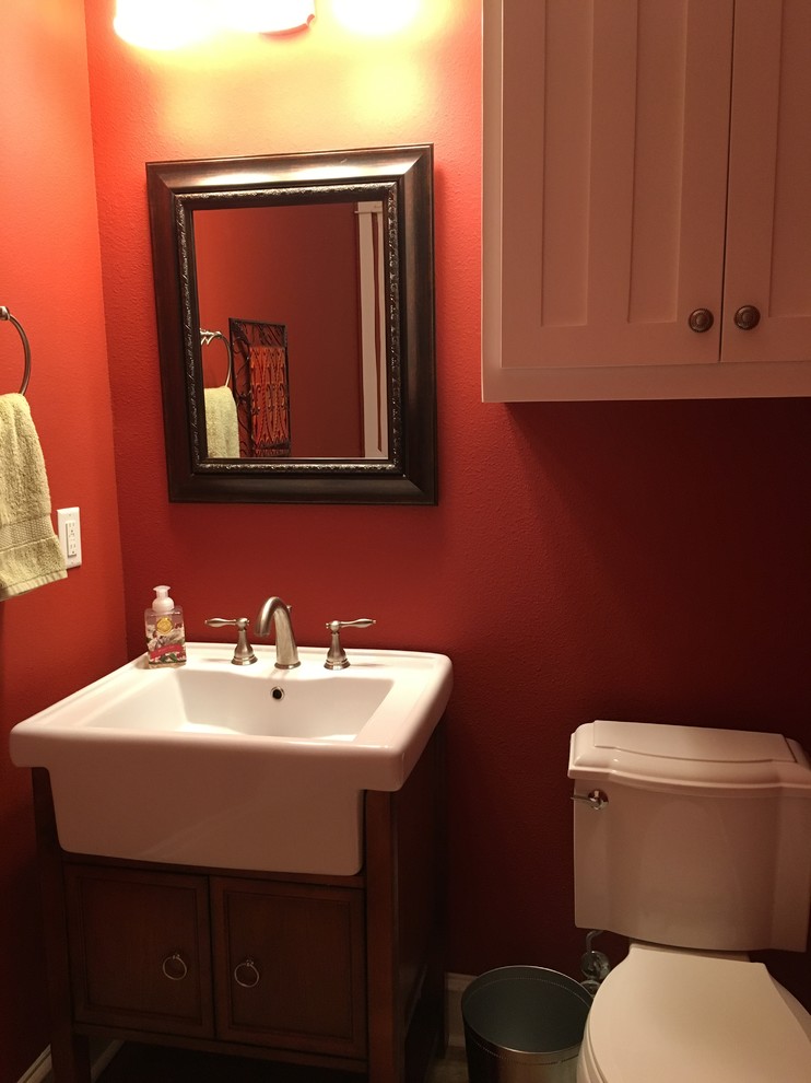 Exempel på ett litet amerikanskt toalett, med vita skåp, en toalettstol med separat cisternkåpa, röda väggar, klinkergolv i keramik och beiget golv