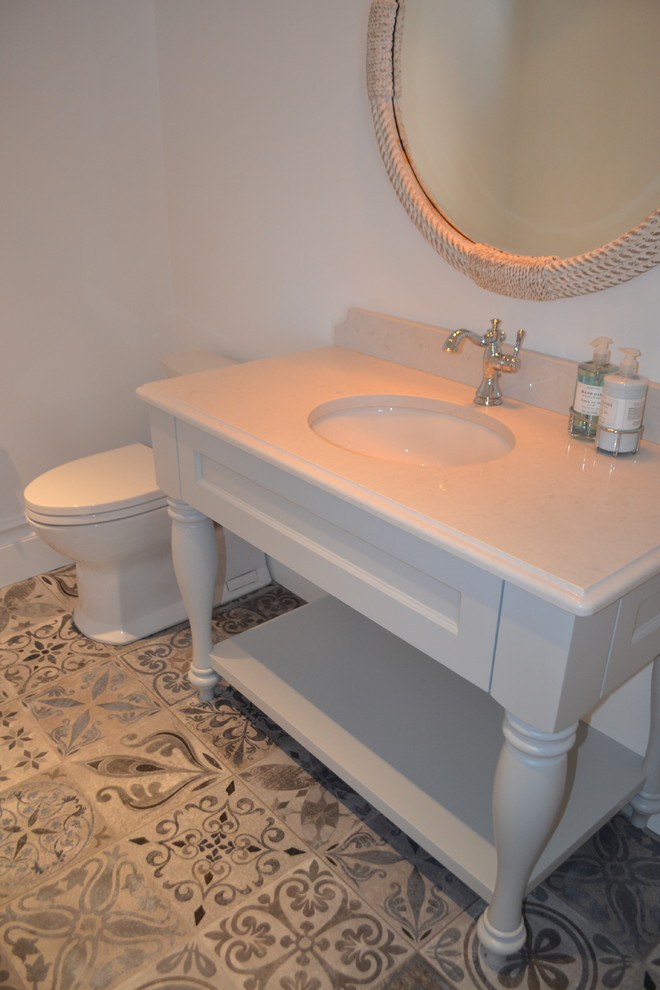 Powder room - mid-sized traditional cement tile floor and brown floor powder room idea in Calgary with open cabinets, white cabinets, a two-piece toilet, white walls, an undermount sink and marble countertops