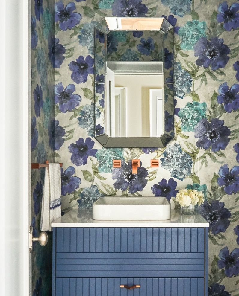 Ispirazione per un bagno di servizio stile marino di medie dimensioni con consolle stile comò, ante blu, lavabo a bacinella, top bianco e pareti multicolore