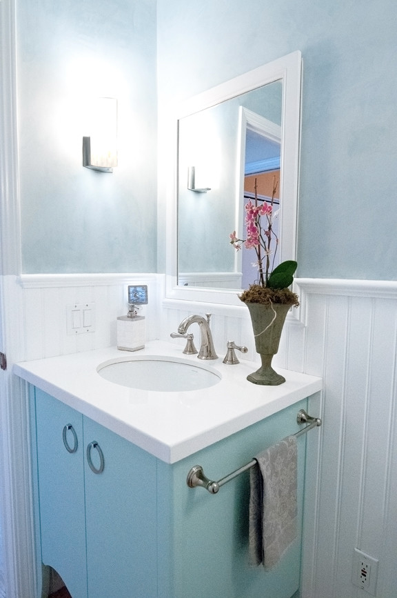 Inspiration för små klassiska toaletter, med ett undermonterad handfat, möbel-liknande, blå skåp, bänkskiva i akrylsten, en toalettstol med hel cisternkåpa och blå väggar