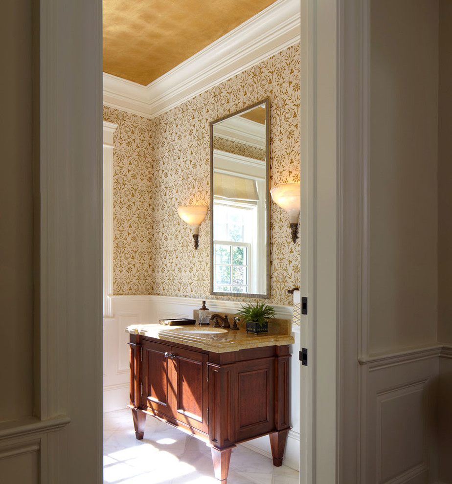 Immagine di un bagno di servizio con lavabo sottopiano, ante in legno bruno, top in marmo, pareti beige e ante con riquadro incassato