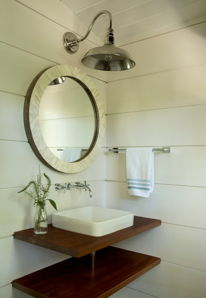 Idée de décoration pour un WC et toilettes champêtre de taille moyenne avec un placard sans porte, un mur blanc, une vasque, un plan de toilette en bois et un plan de toilette marron.
