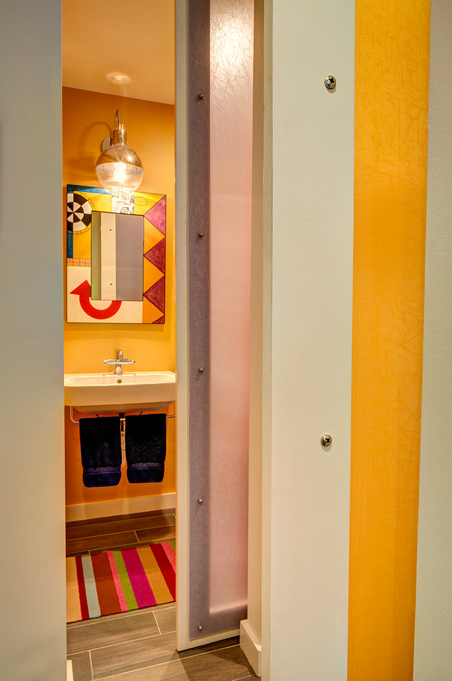 Kleine Moderne Gästetoilette mit Wandtoilette mit Spülkasten, gelber Wandfarbe, Porzellan-Bodenfliesen und Wandwaschbecken in New Orleans