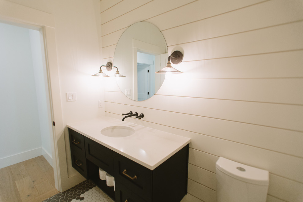 Inredning av ett klassiskt mellanstort toalett, med skåp i shakerstil, svarta skåp, en toalettstol med separat cisternkåpa, vita väggar, klinkergolv i porslin, ett undermonterad handfat, bänkskiva i kvarts och flerfärgat golv
