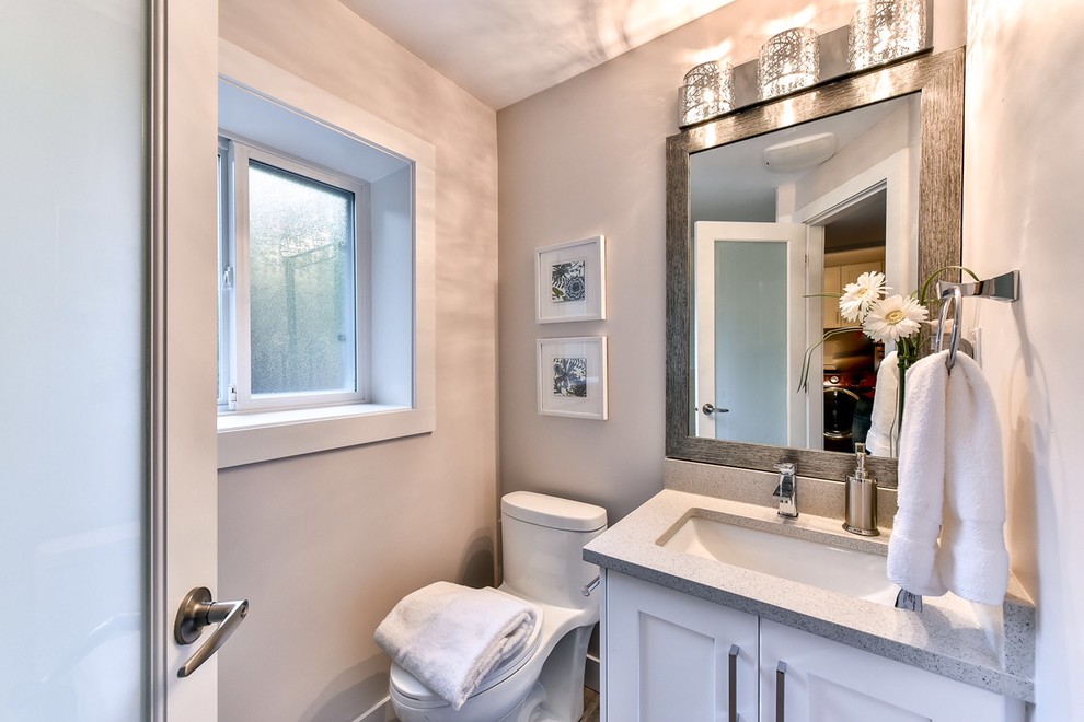 Kleine Klassische Gästetoilette mit Schrankfronten im Shaker-Stil, weißen Schränken, Toilette mit Aufsatzspülkasten, grauen Fliesen, grauer Wandfarbe, Unterbauwaschbecken, Mineralwerkstoff-Waschtisch und grauer Waschtischplatte in Vancouver