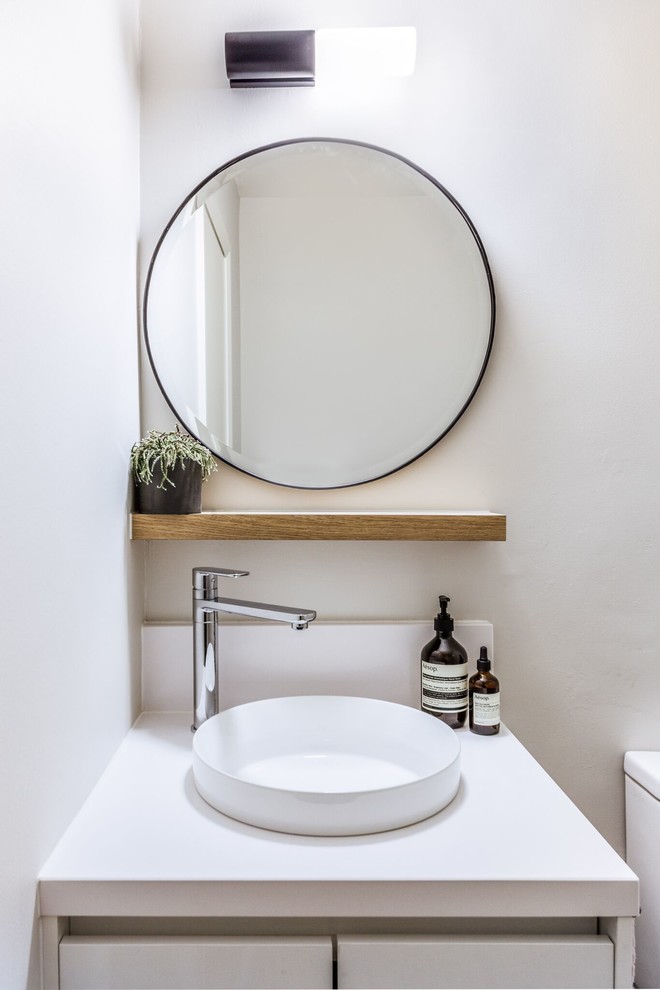 Modern inredning av ett toalett, med skåp i shakerstil, grå kakel, spegel istället för kakel, grå väggar och ett fristående handfat