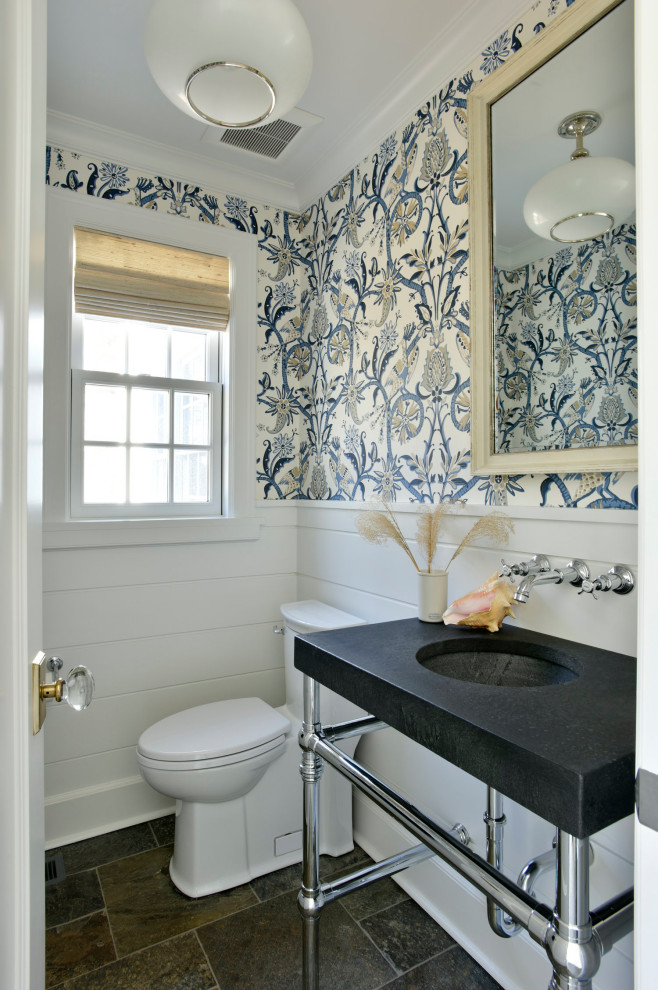 На фото: туалет в классическом стиле с унитазом-моноблоком, разноцветными стенами, врезной раковиной, серым полом, черной столешницей, панелями на стенах и обоями на стенах
