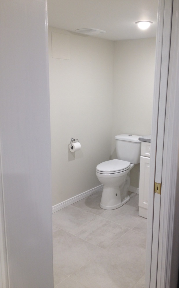 Inspiration pour un petit WC et toilettes design avec un lavabo encastré, un plan de toilette en granite, WC séparés, un carrelage gris, un mur gris et un sol en carrelage de porcelaine.