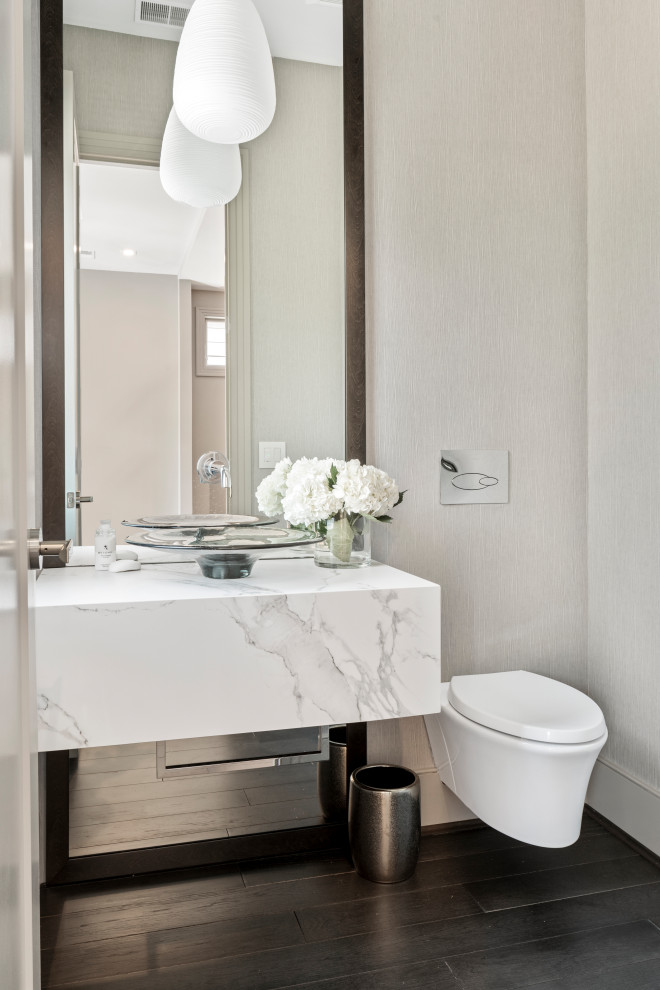 Idée de décoration pour un WC et toilettes design avec un mur gris, parquet foncé, une vasque, un sol marron et un plan de toilette blanc.