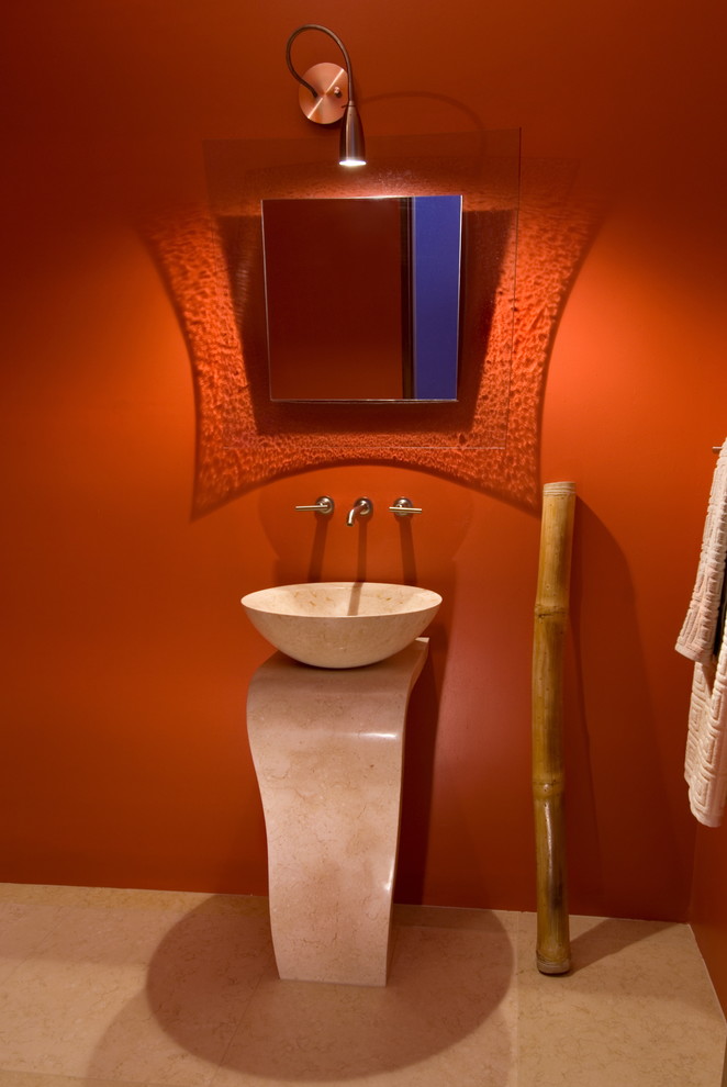 Immagine di un bagno di servizio contemporaneo di medie dimensioni con pareti arancioni, pavimento in pietra calcarea, lavabo a colonna, top in pietra calcarea, pavimento beige e top beige