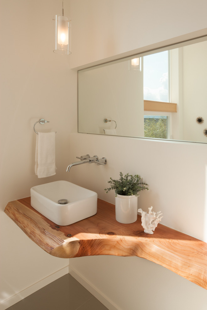 Foto di un piccolo bagno di servizio minimal con lavabo a bacinella, top in legno, pavimento con piastrelle in ceramica e top marrone