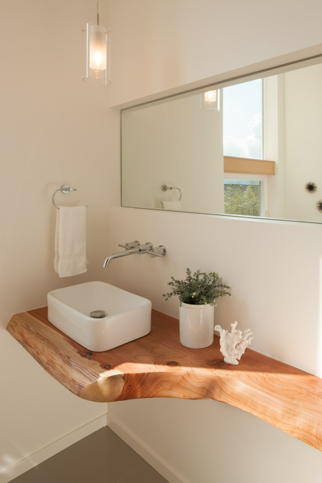 Exemple d'un petit WC et toilettes tendance avec une vasque, un plan de toilette en bois, un sol en carrelage de céramique et un plan de toilette marron.