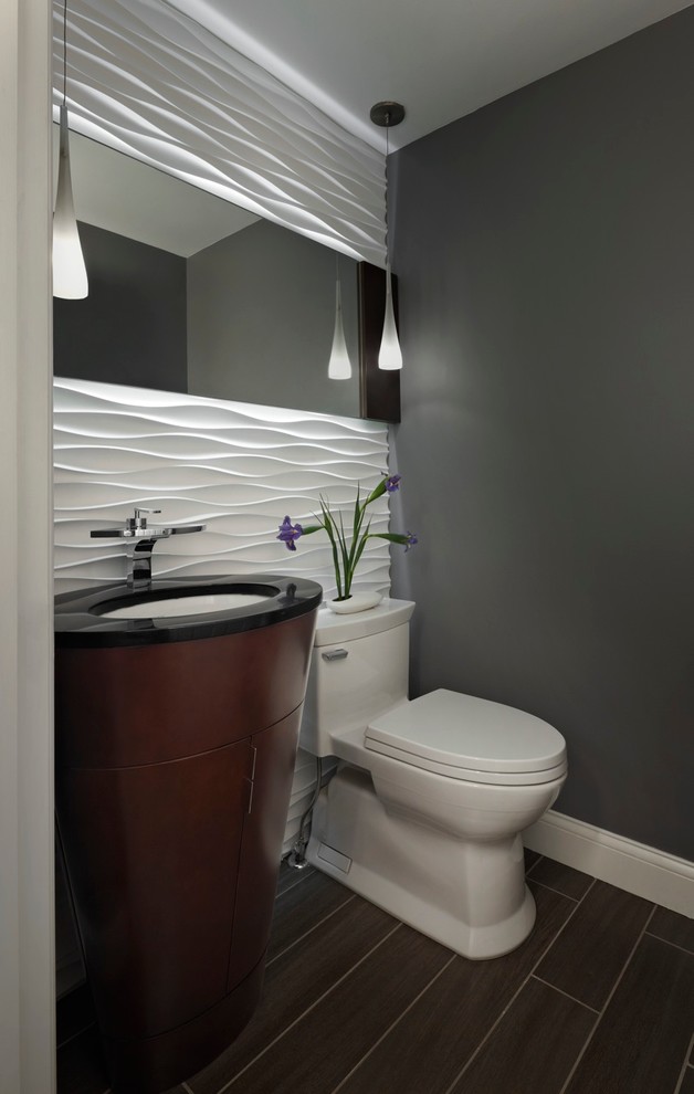 Idée de décoration pour un petit WC et toilettes design en bois foncé avec un lavabo encastré, un placard en trompe-l'oeil, un plan de toilette en granite, un carrelage blanc, un carrelage gris, un mur gris, un sol en carrelage de porcelaine et WC à poser.