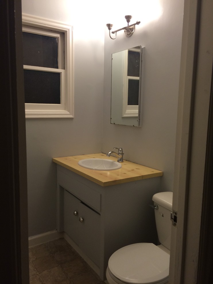 Foto di un piccolo bagno di servizio eclettico con lavabo da incasso, ante grigie, top in legno, WC a due pezzi e pareti grigie