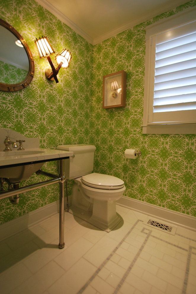 Inredning av ett litet grå grått toalett, med öppna hyllor, en toalettstol med separat cisternkåpa, gröna väggar, marmorgolv, ett undermonterad handfat, bänkskiva i kvarts och vitt golv