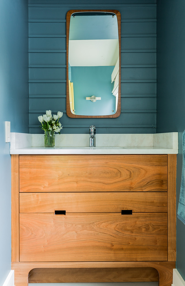Foto di un piccolo bagno di servizio classico con ante lisce, ante in legno scuro, pareti blu, lavabo sottopiano e top in marmo