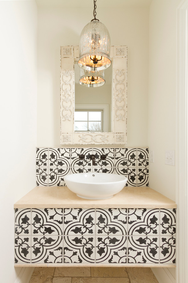 Inredning av ett medelhavsstil litet toalett, med ett fristående handfat, bänkskiva i kalksten, cementkakel, vita väggar, travertin golv, svart och vit kakel och beige kakel