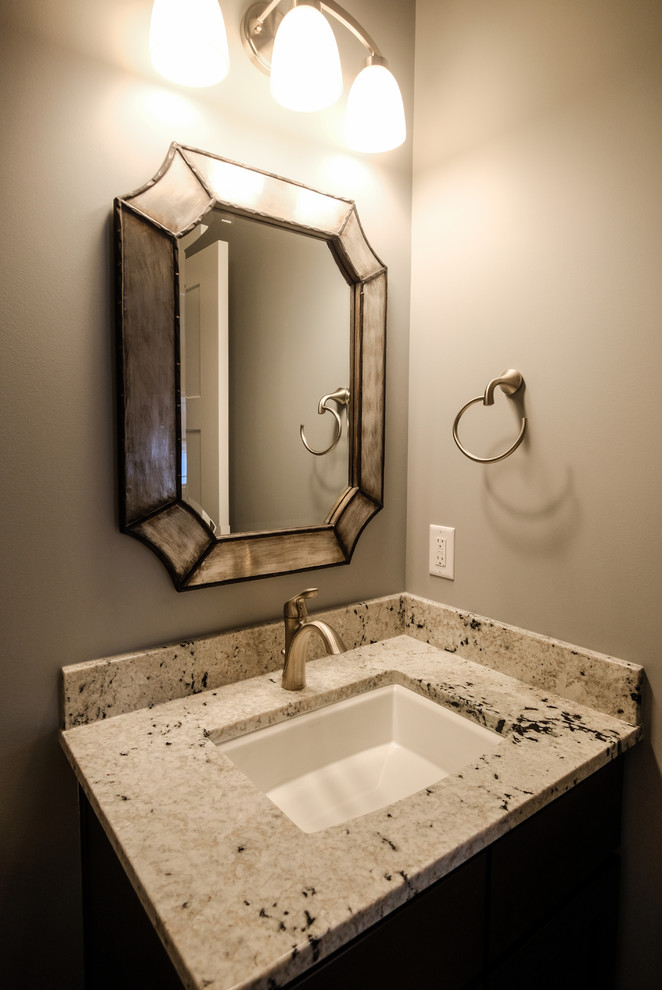 Immagine di un bagno di servizio classico di medie dimensioni con ante in legno bruno, lavabo sottopiano, top in granito, pareti grigie e top beige