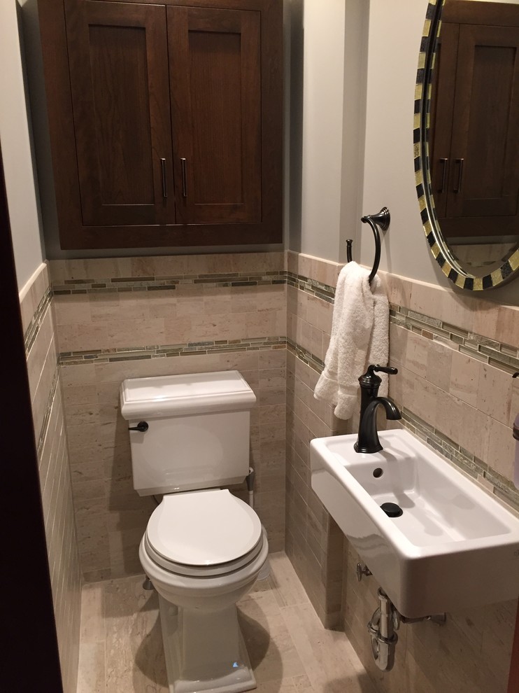 Small traditional cloakroom in New York with shaker cabinets, dark wood cabinets, a two-piece toilet, beige tiles, ceramic flooring and a wall-mounted sink.