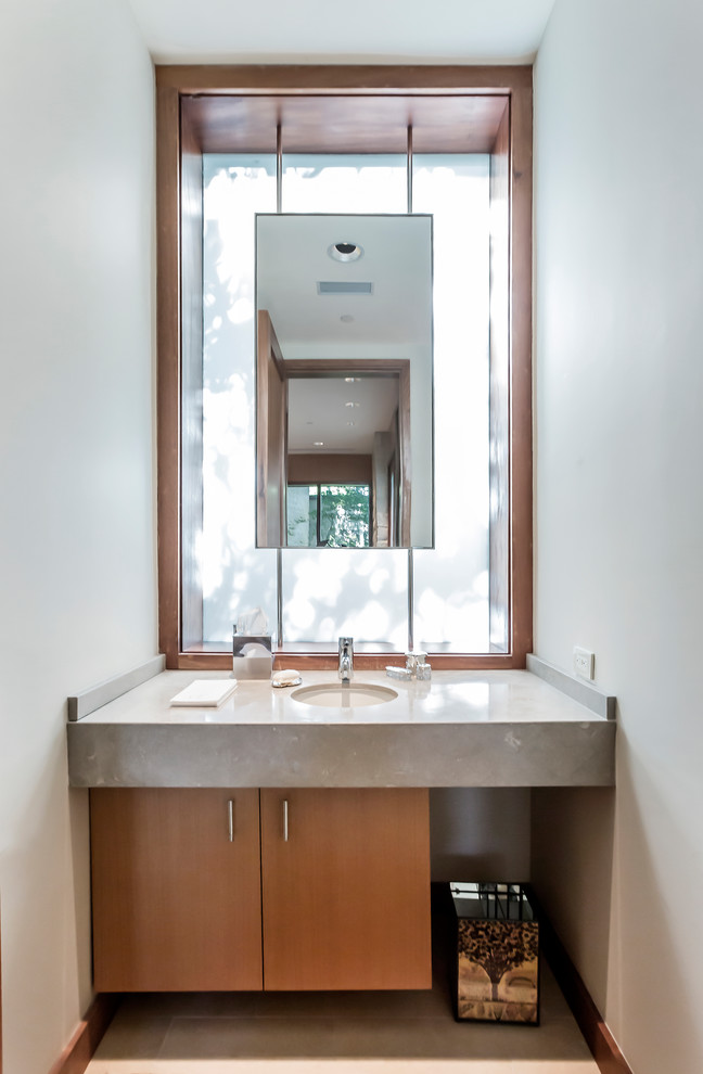 Cette photo montre un WC et toilettes tendance de taille moyenne avec un placard à porte plane, des portes de placard beiges, un mur blanc, un sol en carrelage de porcelaine, un lavabo encastré, un plan de toilette en marbre et un sol beige.
