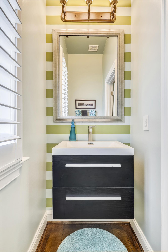 ワシントンD.C.にあるトランジショナルスタイルのおしゃれなトイレ・洗面所 (フラットパネル扉のキャビネット、黒いキャビネット、マルチカラーの壁、濃色無垢フローリング、コンソール型シンク、茶色い床) の写真