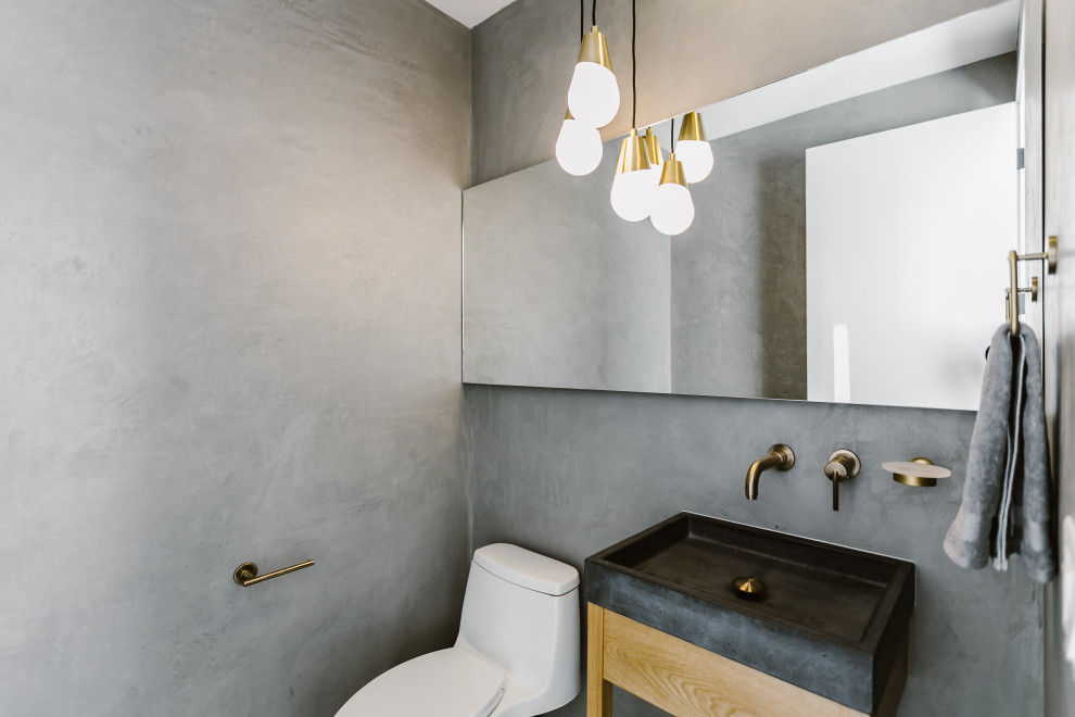 Idéer för ett litet minimalistiskt grå toalett, med skåp i ljust trä, en toalettstol med hel cisternkåpa, grå kakel, grå väggar, klinkergolv i porslin, ett konsol handfat, bänkskiva i betong och grått golv