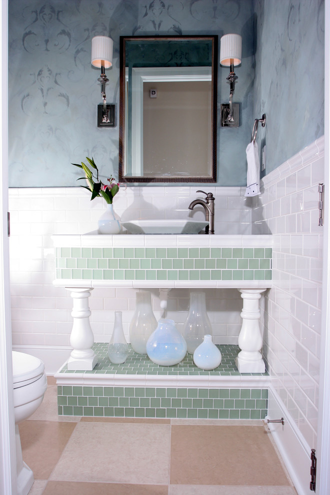 Bild på ett litet vintage toalett, med beige kakel, porslinskakel, en toalettstol med separat cisternkåpa, ett fristående handfat, blå väggar, klinkergolv i porslin och kaklad bänkskiva