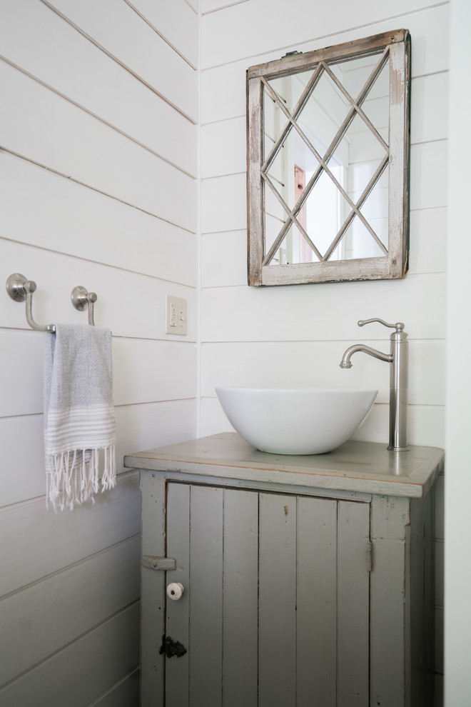 Landhausstil Gästetoilette mit verzierten Schränken, Schränken im Used-Look, weißer Wandfarbe, Aufsatzwaschbecken, Waschtisch aus Holz und grauer Waschtischplatte in Portland Maine