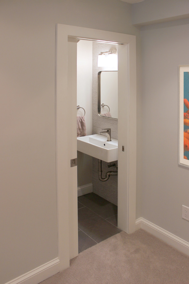 На фото: туалет среднего размера в стиле неоклассика (современная классика) с открытыми фасадами, серой плиткой, керамической плиткой, серыми стенами, полом из керамогранита, подвесной раковиной и серым полом с
